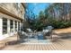 Relaxing outdoor deck with wooded view, stylish seating arrangement, and a gas grill at 11120 Surrey Park Trail, Johns Creek, GA 30097