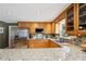 Kitchen with granite countertops, stainless steel refrigerator, and wood cabinetry at 957 Ross Ct, Stone Mountain, GA 30087