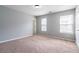 Spacious bedroom with neutral walls, plush carpeting, and two windows for natural light at 32 Hampton Dr, Cartersville, GA 30121
