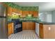Cozy kitchen featuring wooden cabinets, a black oven, and eye-catching green leaf-patterned wallpaper at 32 Hampton Dr, Cartersville, GA 30121