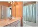 Well-lit bathroom featuring a vanity, a mirror, and shower with light green curtain at 397 4Th Ne St, Atlanta, GA 30308