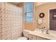 A bright bathroom featuring white fixtures, a shower with patterned curtain, and a large window at 397 4Th Ne St, Atlanta, GA 30308