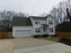 Charming two-story home with attached garage, landscaped yard, and a paved driveway at 554 Samaritan Dr, Cumming, GA 30040