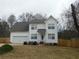 Desirable two-story home with attached garage, landscaped yard, and a paved driveway at 554 Samaritan Dr, Cumming, GA 30040