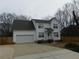 Charming two-story home with attached garage, landscaped yard, and a paved driveway at 554 Samaritan Dr, Cumming, GA 30040