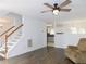 Living room with hardwood floors, stairs, and ceiling fan provides access to other living spaces at 554 Samaritan Dr, Cumming, GA 30040