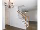 Bright staircase with white railing, hardwood steps, and chandelier lighting at 554 Samaritan Dr, Cumming, GA 30040