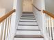 Bright staircase with white railing and stained hardwood steps and handrail at 554 Samaritan Dr, Cumming, GA 30040