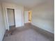 A carpeted bedroom with a closet and a doorway, ready to be updated to your style at 7402 Gossamer St, Union City, GA 30291