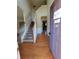Inviting entryway with hardwood floors, staircase with white banister, and view to other rooms at 7402 Gossamer St, Union City, GA 30291