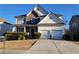 Charming two-story home with stone accents, a two-car garage and a well-manicured lawn at 7402 Gossamer St, Union City, GA 30291