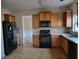 Functional kitchen featuring wood cabinets, black appliances, and ample counter space at 7402 Gossamer St, Union City, GA 30291