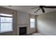 Comfortable living room featuring a fireplace, windows for natural light, and a ceiling fan at 7402 Gossamer St, Union City, GA 30291