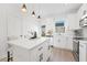 Contemporary kitchen with white cabinets, quartz countertop island, and modern pendant lighting at 170 Chandler Trace, Covington, GA 30016