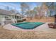 Backyard view of a covered swimming pool, with a firepit, gazebo and the rear of the home at 320 Red Fox Dr, Canton, GA 30114