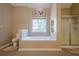 Modern bathroom with a soaking tub, glass-enclosed shower, and a large window at 320 Red Fox Dr, Canton, GA 30114
