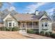 Charming home showcasing a covered front porch with stone accents and mature landscaping at 320 Red Fox Dr, Canton, GA 30114