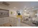 Basement living room with kitchenette, white cabinets, furniture, rug, ceiling fan, and lighting at 320 Red Fox Dr, Canton, GA 30114