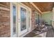 A covered front porch featuring stone accents, rocking chairs, and a decorative front door at 320 Red Fox Dr, Canton, GA 30114