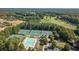 Aerial view featuring the tennis courts and pool facilities, surrounded by trees and a golf course at 3690 Millwater Xing, Dacula, GA 30019