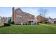 Backyard view of a brick home showcasing a spacious lawn, deck and multiple windows for natural light at 3690 Millwater Xing, Dacula, GA 30019