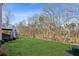 Expansive backyard with lush lawn, mature trees, and a staircase to the deck above at 3690 Millwater Xing, Dacula, GA 30019