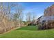 Green backyard with mature trees and landscaping, and a deck overlooking the serene space at 3690 Millwater Xing, Dacula, GA 30019