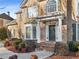 Inviting front porch with brick steps, decorative columns, and a stylish front door with a wreath at 3690 Millwater Xing, Dacula, GA 30019