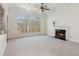 Bright living room with fireplace, large windows with backyard views, and a tray ceiling at 3690 Millwater Xing, Dacula, GA 30019
