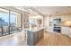 Bright kitchen with white cabinets, an island, and a sliding glass door to a balcony with a city view at 75 14Th Ne St # 3160, Atlanta, GA 30309