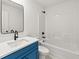Modern bathroom features a blue vanity, white countertop, and a shower-tub combination at 150 Chandler Trace, Covington, GA 30016
