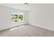 Bright, carpeted bedroom with a large window offering a view of a home exterior at 150 Chandler Trace, Covington, GA 30016