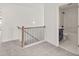 Upstairs hallway with gray carpet, decorative railing, and an adjacent full bathroom at 150 Chandler Trace, Covington, GA 30016