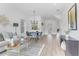 Open-concept living room with modern decor, wood flooring and chandelier over dining area at 150 Chandler Trace, Covington, GA 30016