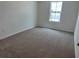 Well-lit bedroom boasts a window, neutral walls, and cozy carpeting at , Conyers, GA 30094