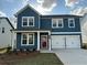 Two-story blue home featuring a red door, white trim, two-car garage and well-maintained lawn at , Conyers, GA 30094
