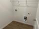 A practical laundry area with wood-look flooring, utility connections, and wire shelving at , Conyers, GA 30094