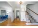 Bright foyer showcasing hardwood floors, staircase with patterned runner, and elegant lighting fixture at 4650 Sharon Valley Ct, Atlanta, GA 30360