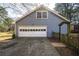 View of the two-car garage with traditional doors and a cracked concrete driveway at 4650 Sharon Valley Ct, Atlanta, GA 30360