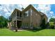 Brick home exterior featuring a screened porch, stone patio, and manicured lawn at 4880 Cecilia Sq, Cumming, GA 30040
