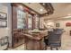 Stylish basement bar with custom cabinetry, glassware storage, recessed lighting, and leather bar stools at 4880 Cecilia Sq, Cumming, GA 30040