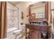 Well-appointed bathroom featuring a shower and tub combo, an antique vanity with a dark countertop, and a framed mirror at 4880 Cecilia Sq, Cumming, GA 30040