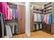 Spacious walk-in closet with custom shelving and wooden floors for optimal storage and organization at 4880 Cecilia Sq, Cumming, GA 30040