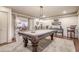Large billiards room with a pool table, decorative lighting, hardwood floors, and a sitting area at 4880 Cecilia Sq, Cumming, GA 30040