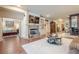 Open-concept living room featuring a fireplace, built-in shelving, hardwood floors, and easy access to the Primary bedroom at 4880 Cecilia Sq, Cumming, GA 30040