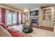 Cozy living room featuring a fireplace, built-in shelving, hardwood floors, and french doors with backyard access at 4880 Cecilia Sq, Cumming, GA 30040