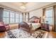 Elegant main bedroom with large windows, tray ceiling, and a dark wood sleigh bed at 4880 Cecilia Sq, Cumming, GA 30040