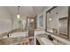 Bathroom with tub, shower, and granite topped vanity with a decorative mirror and modern pendant lighting at 3075 Elizabeth Ln, Snellville, GA 30078