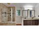 Bathroom features tiled shower with glass door and a dual sink vanity with granite counters and wood cabinets at 3075 Elizabeth Ln, Snellville, GA 30078