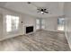 Open living area with fireplace, wood flooring, ceiling fan, and large windows at 3075 Elizabeth Ln, Snellville, GA 30078